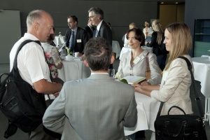 Foto einer Gruppe Teilnehmerinnen und Teilnehmer diskutierend an einem Stehtisch